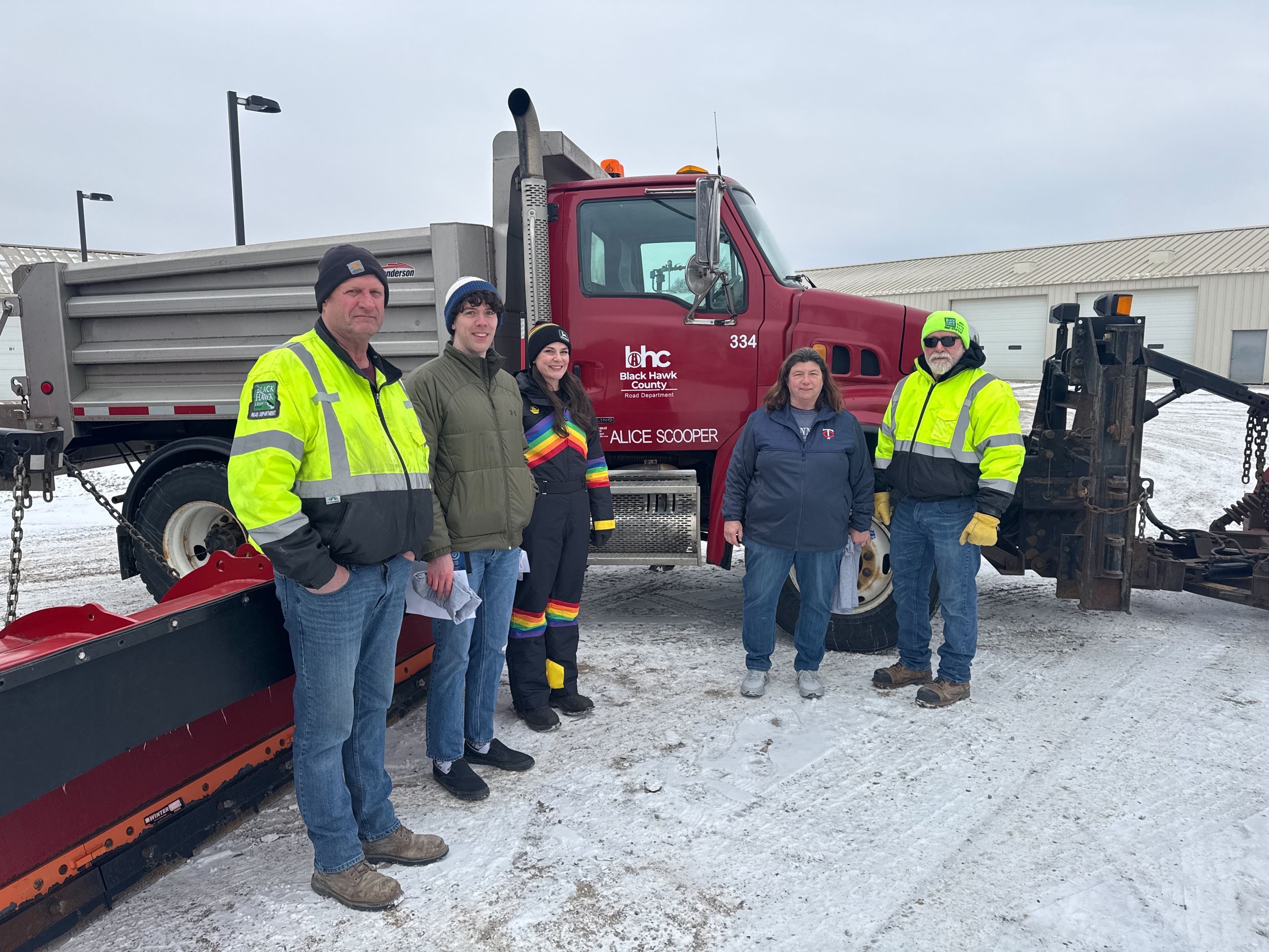 Image of three contest winners and roads staff in front of BHC snowplow